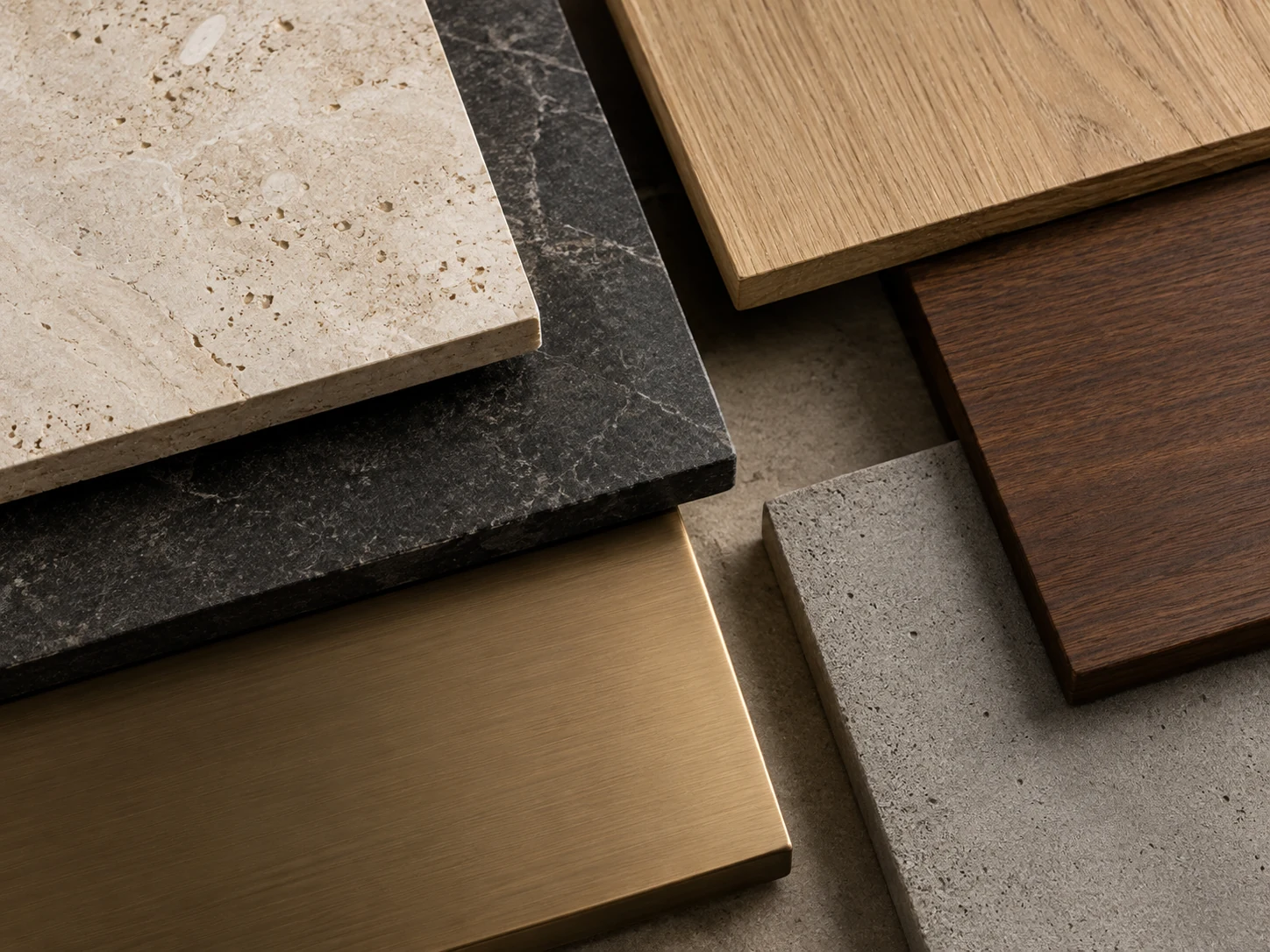 A curated arrangement of stone, timber, concrete and brushed bronze material samples